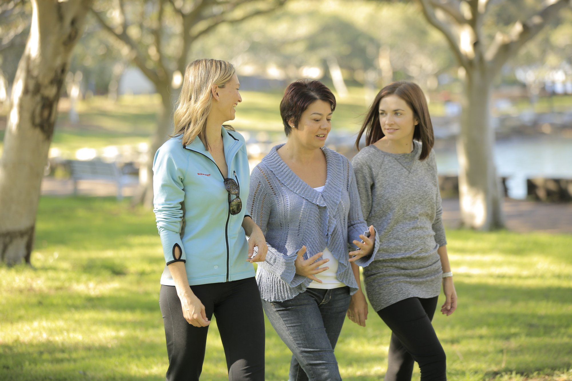 Three women walking and chatting with each other