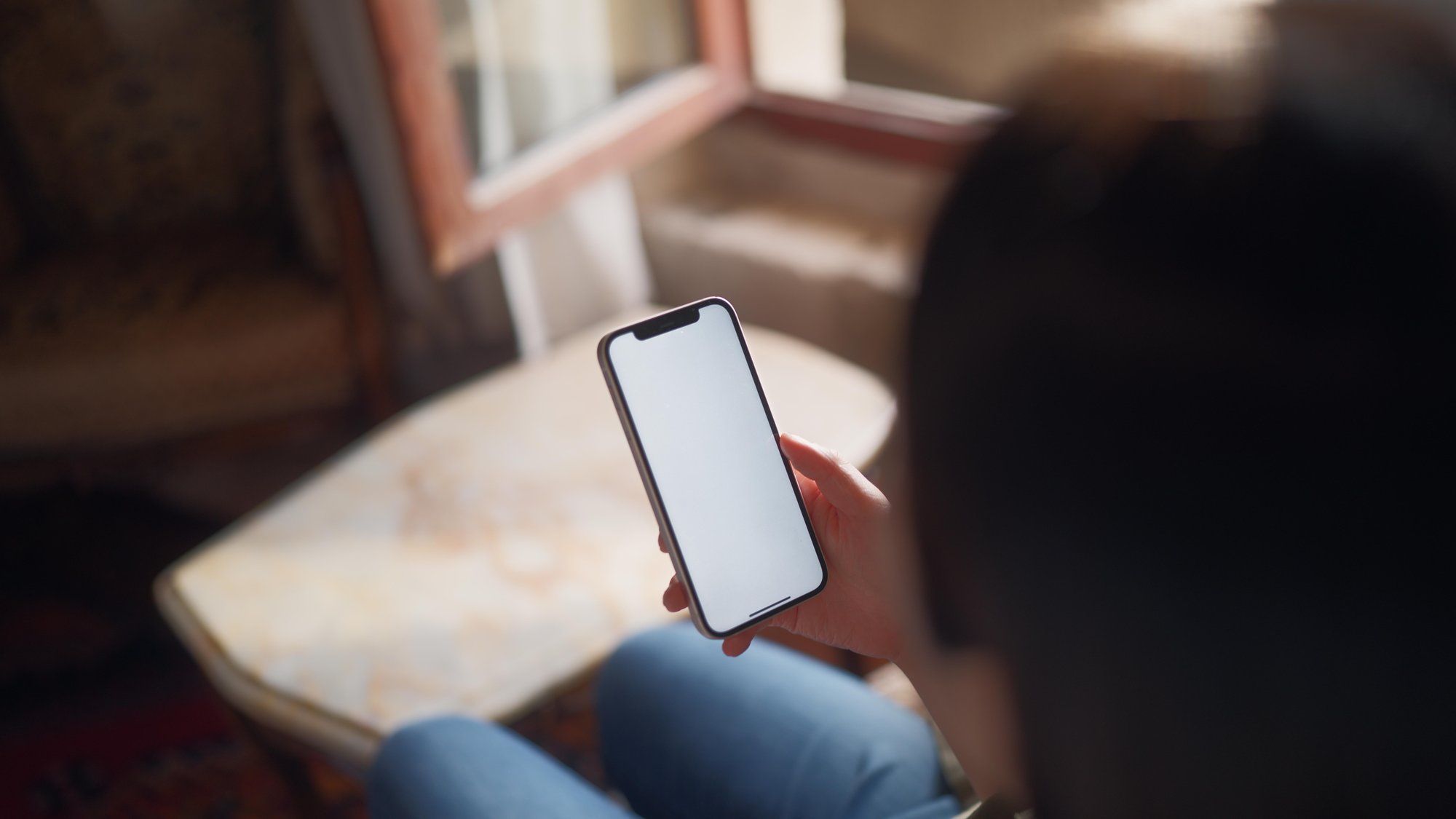 Young female tourist relaxing and using her smart phone in hotel room